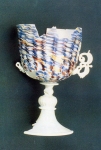 Tra i vetri di eccezionale valore storico, questo calice, con stelo e coppa decorati a stampo in vetro opaco bianco, detto lattino, con striature dai colori blu, rosso e dorato.